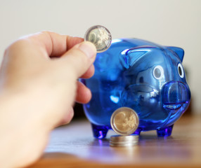 Blaues Sparschwein und Münzen