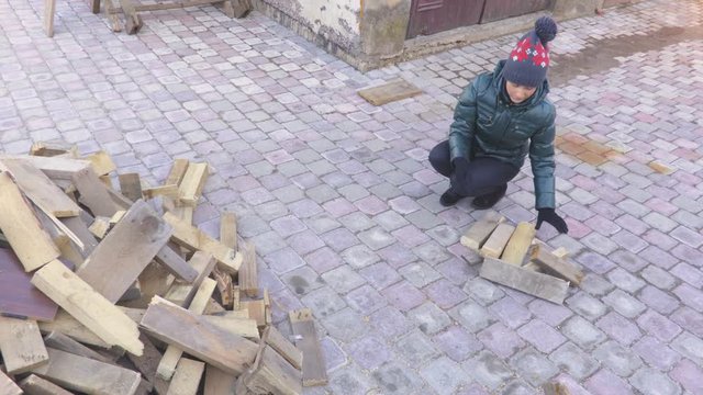  Woman collect firewood in yard
