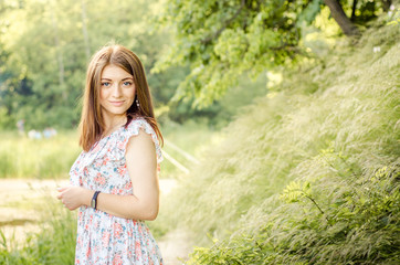 fashionable young healthy woman smiling  in stylish trendy dress on the background of nature