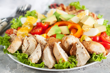 Salad with vegetables, bacon, chicken and eggs