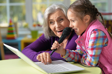 senior woman with granddaughter singing karaoke