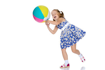 Little girl is playing with a ball