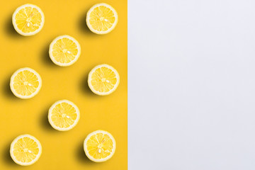 Lemon halves on split color, yellow and white background with copy space for text.