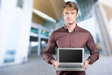 Young caucasian man with portable pc in his hands