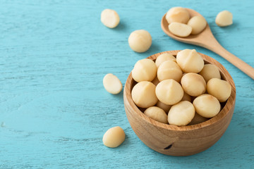 Macadamia nuts on blue wooden table background