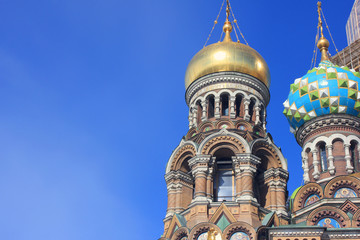 Fototapeta na wymiar Onion Domes and Ornamental Details Architecture of Church of Our Savior on Spilled Blood in Saint Petersburg, Russia. Top of Religious Building, Exterior View of Old Historic Cathedral on Sunny Day.