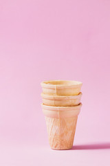Stack of empty waffle cups for ice cream over pink pastel pin-up background. Copy space.