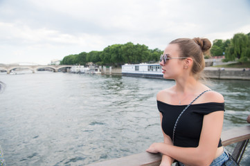Fototapeta premium Woman look at seine river in paris, france. Sensual woman in sunglasses on bridge on summer day. Vacation and wanderlust concept