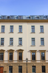 Modern Style Old Building Classical Architecture. Facade of Old Historical Minimalist House with Beige Walls. Apartment and Office Building Exterior Front View with Simple Square Windows in Row.