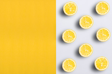 Lemon halves on split color, yellow and white background with copy space for text.