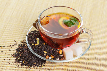 cup of black tea with mint leaves on a wooden table