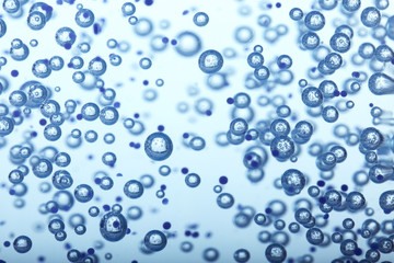 Oxygen bubbles in clear blue water, close-up. Mineral water. Water enriched with oxygen.