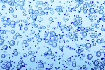 Oxygen bubbles in clear blue water, close-up. Mineral water. Water enriched with oxygen.