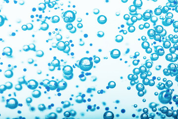Oxygen bubbles in clear blue water, close-up. Mineral water. Water enriched with oxygen.