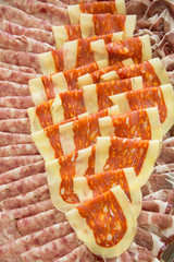 Italian mixed cold cuts spicy cooked sausages. tray with different italian types of salami, seen from above