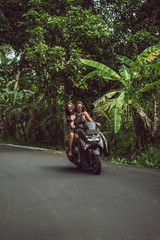 attractive young women riding motorcycle on road in jungles