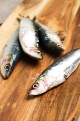Sardinas sobre frescas y crudas sobre una tabla de madera rústica. Vista superior y de cerca