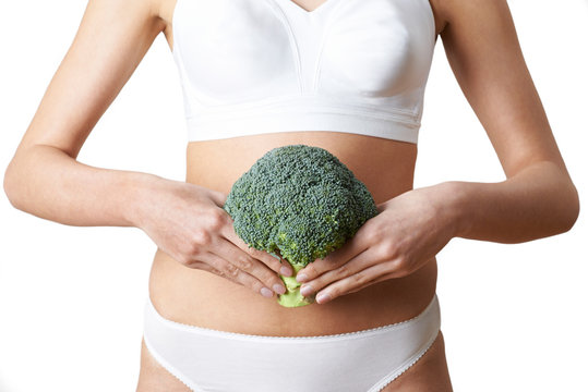 Close Up Of Woman In Underwear Holding Bunch Of Broccoli And Touching Stomach