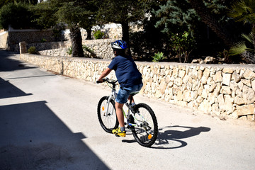 Naklejka premium a boy in a blue helmet riding a bike down the street