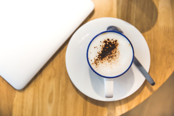 laptop with fresh cup of coffee, top view.