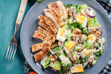 Healthy caesar salad with chicken, eggs and croutons