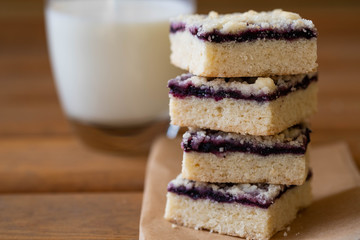 Stack of cake or cookies with jam or marmalade with sweet crumbs, cinnamon and nuts on a parchment paper.