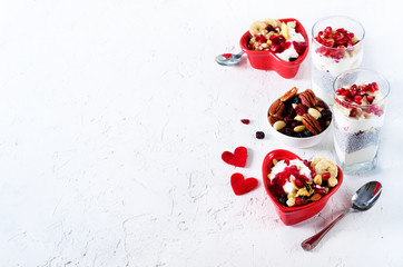 Romantic breakfast with chia, granola, yogurt and berries on old white concrete background. Health and diet concept.