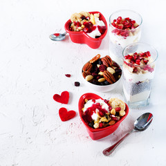 Healthy breakfast - pomegranate, yogurt, granola parfait on white concrete background. Romantic time.