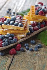  Yummy sweet waffles with raspberries and blueberries .