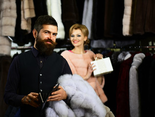 Guy with beard and woman buy coat. Man with wallet