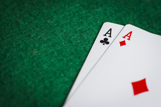A pair of aces on a green poker table