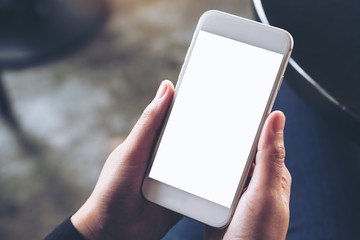 Mockup image of hands holding white mobile phone with blank desktop screen