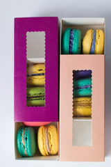 mix of macaroons in purple and pink boxes