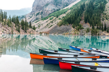 Multicolored canoes on the surface of a mountain lake