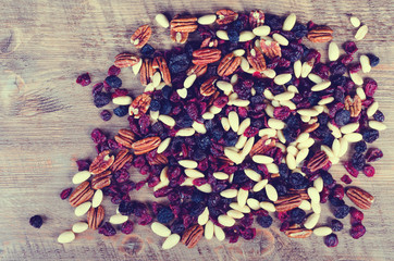 Dried fruits, nuts frame on rustic wooden background.