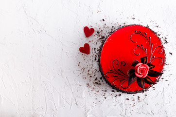 Red Cake with rose, two hearts on white concrete background. Top view. Valentine's Day. Free space for your text.