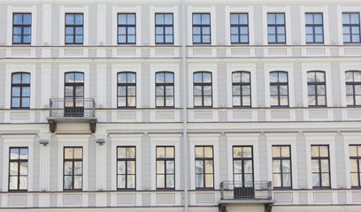 Fototapeta na wymiar Historic Building Facade Architecture Classic Old House Close Up View in Saint Petersburg, Russia. Classic European City Apartment Building Exterior, Front View with Windows in Row and Small Balcony.