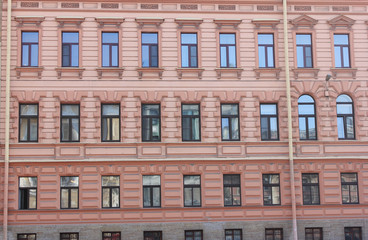 Architecture Building Classic Decor Facade of Old Historic House with Soft Light Red Color Walls. Exterior Design of Apartment Building Front View. Minimalist Style European Architecture.