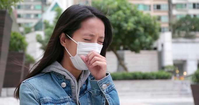 Woman feeling sick and wearing face mask