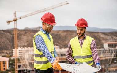 Builders on residential construction site looking the building project
