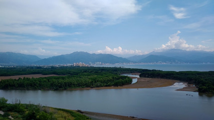 Puerto Vallarta, Mexiko am Morgen, Sonnenaufgang, von der Wasserseite, mit Aussicht auf Zentrum, Meer, Berge und Mangroven