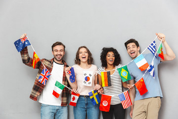 Happy group of friends holding a lot of international flags.