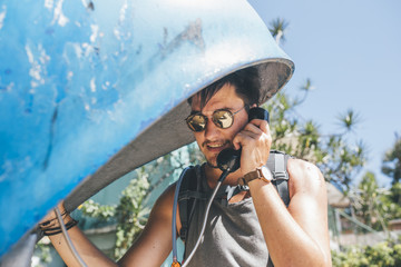 Cuba, Young man making a call from a telephone booth