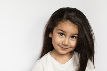 Portrait of happy smiling brunette child girl with long hear isolated on white background. Place for text.