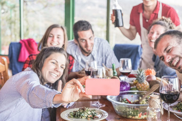 Happy friends taking selfie during vegetarian dinner at home