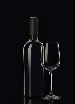 Bottle of red wine and glass on black background