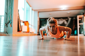 Obraz na płótnie Canvas Determined young woman doing push ups.