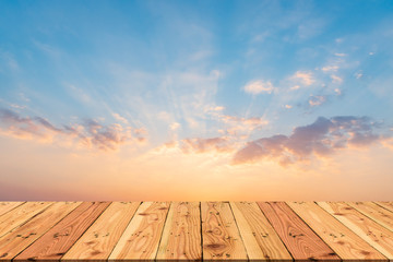 Wooden table on Beautiful dramatic sunset sky with orange and blue colored clouds for spring or summer concept.