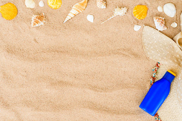 Top view of sunglasses, hat beach, shell and sunscreen on sand beach background for summer holiday concept.