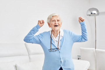 Seniorin jubelt mit geballten Fäusten